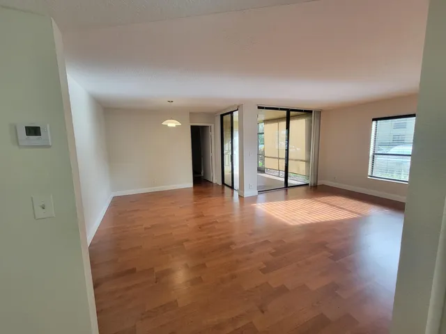 a view of an empty room with wooden floor