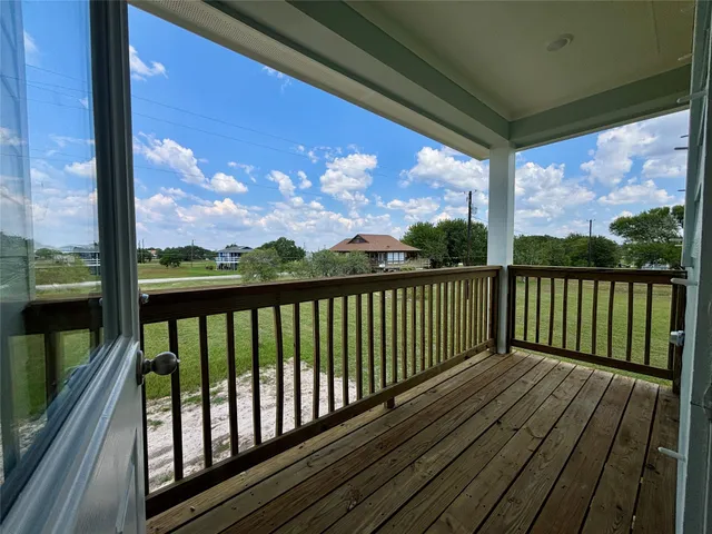 a view of balcony with wooden floor & fence