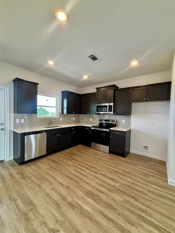 a kitchen with stainless steel appliances granite countertop a stove a sink and a refrigerator