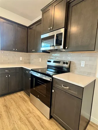 a large kitchen with wooden floor and a sink