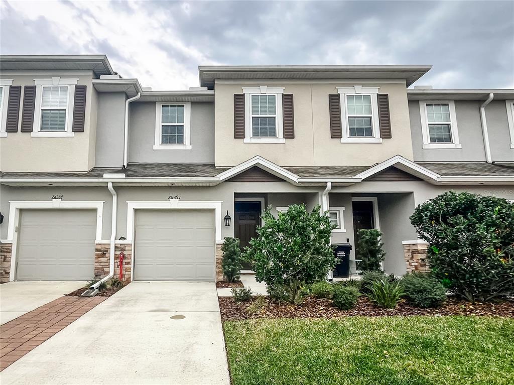 26391 Limestone Springs Way Wesley Chapel, FL 33544 - Photo 1 of 16 a front view of a house with a yard and garage