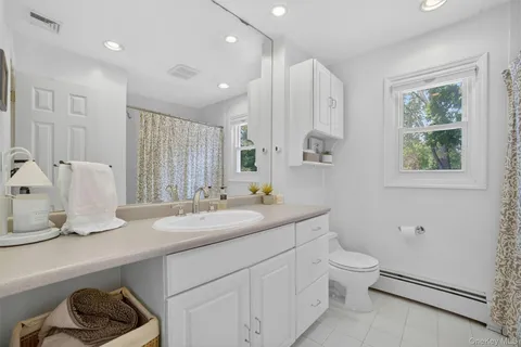 a bathroom with a double vanity sink a toilet and a mirror