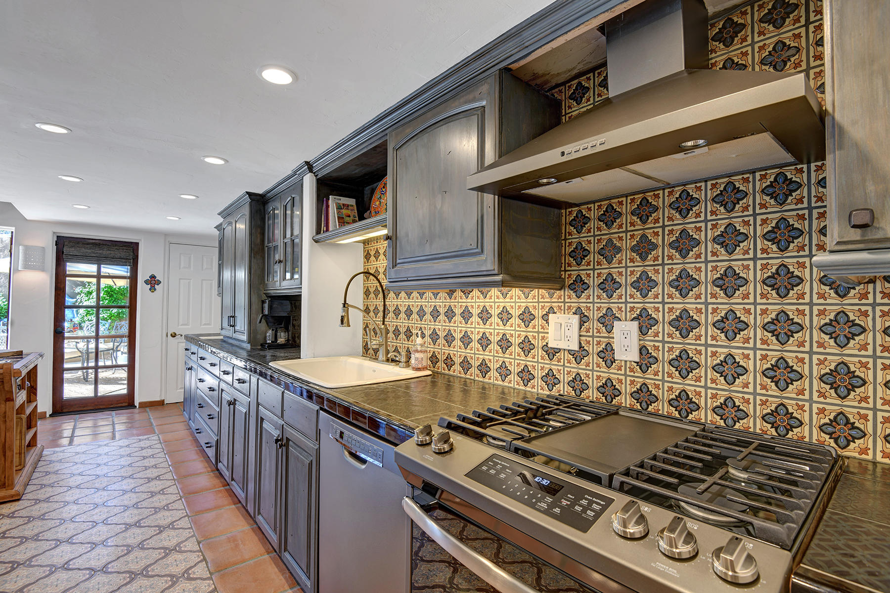 71677 Tunis Road Rancho Mirage, CA 92270 - Photo 12 of 37 a kitchen with granite countertop a stove and a wooden cabinets