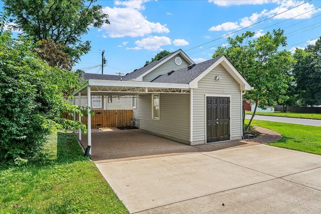 a view of a house with a yard and potted plants