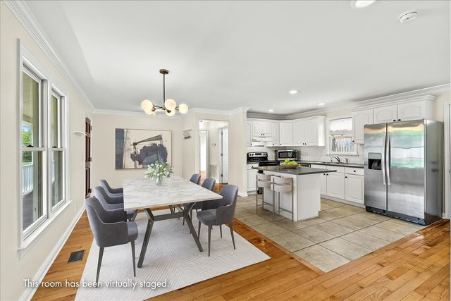 a kitchen with granite countertop refrigerator dining table and chairs