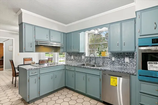 a kitchen with kitchen island granite countertop appliances cabinets and a sink