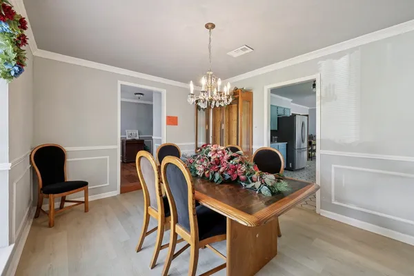 a view of a dining room with furniture a chandelier and window