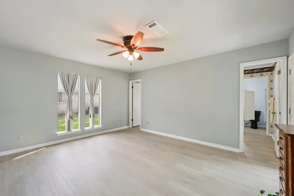 an empty room with closet and windows
