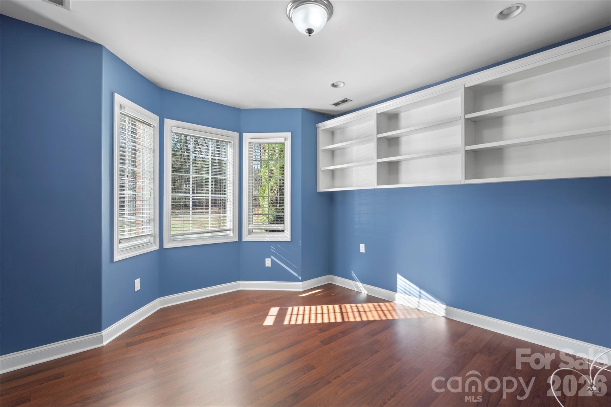 12711 Moores Chapel Road Charlotte, NC 28214 - Photo 21 of 48 a view of an empty room with wooden floor and a window