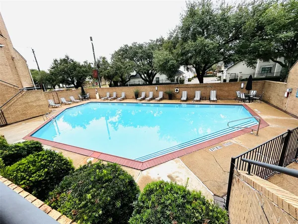 a view of a swimming pool with an outdoor seating and a bench