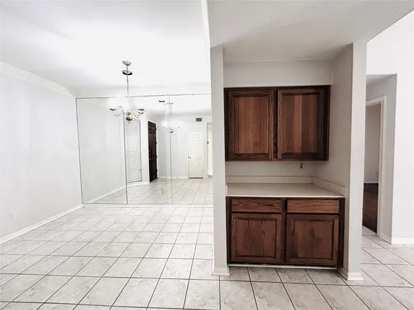 a view of a refrigerator in kitchen and an empty room