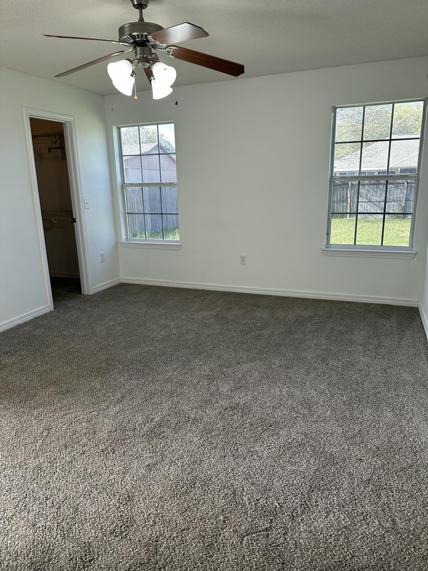 4195 Berry Circle Pace, FL 32571 - Photo 20 of 50 an empty room with chandelier fan and windows
