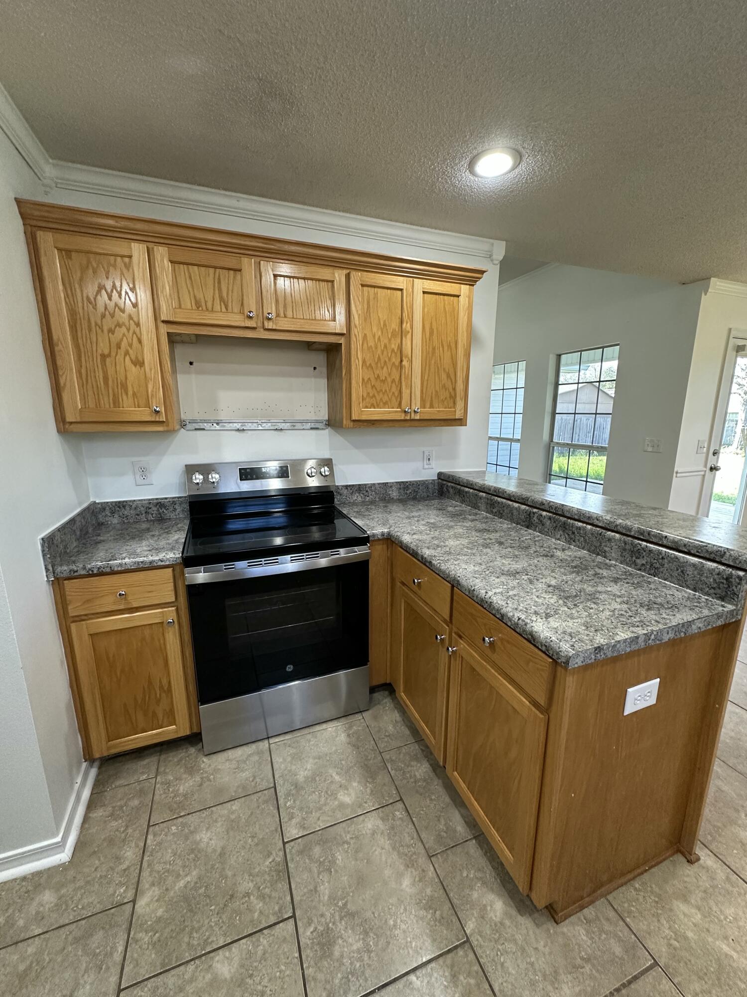 4195 Berry Circle Pace, FL 32571 - Photo 37 of 50 a kitchen with granite countertop a stove sink and cabinets