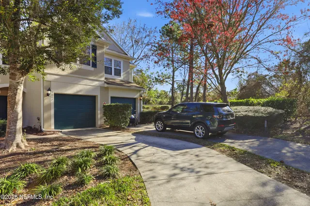 a view of a house with a small yard and sitting area