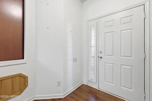 a view of an empty room with wooden floor and closet
