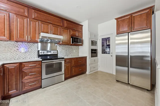 a kitchen with stainless steel appliances granite countertop a refrigerator stove and sink