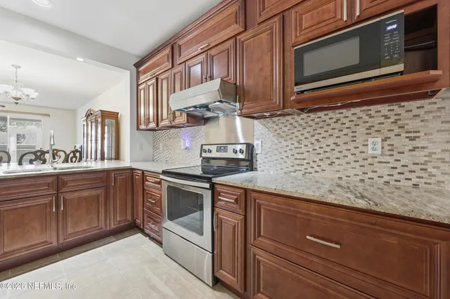 a kitchen with stainless steel appliances granite countertop a sink stove and microwave