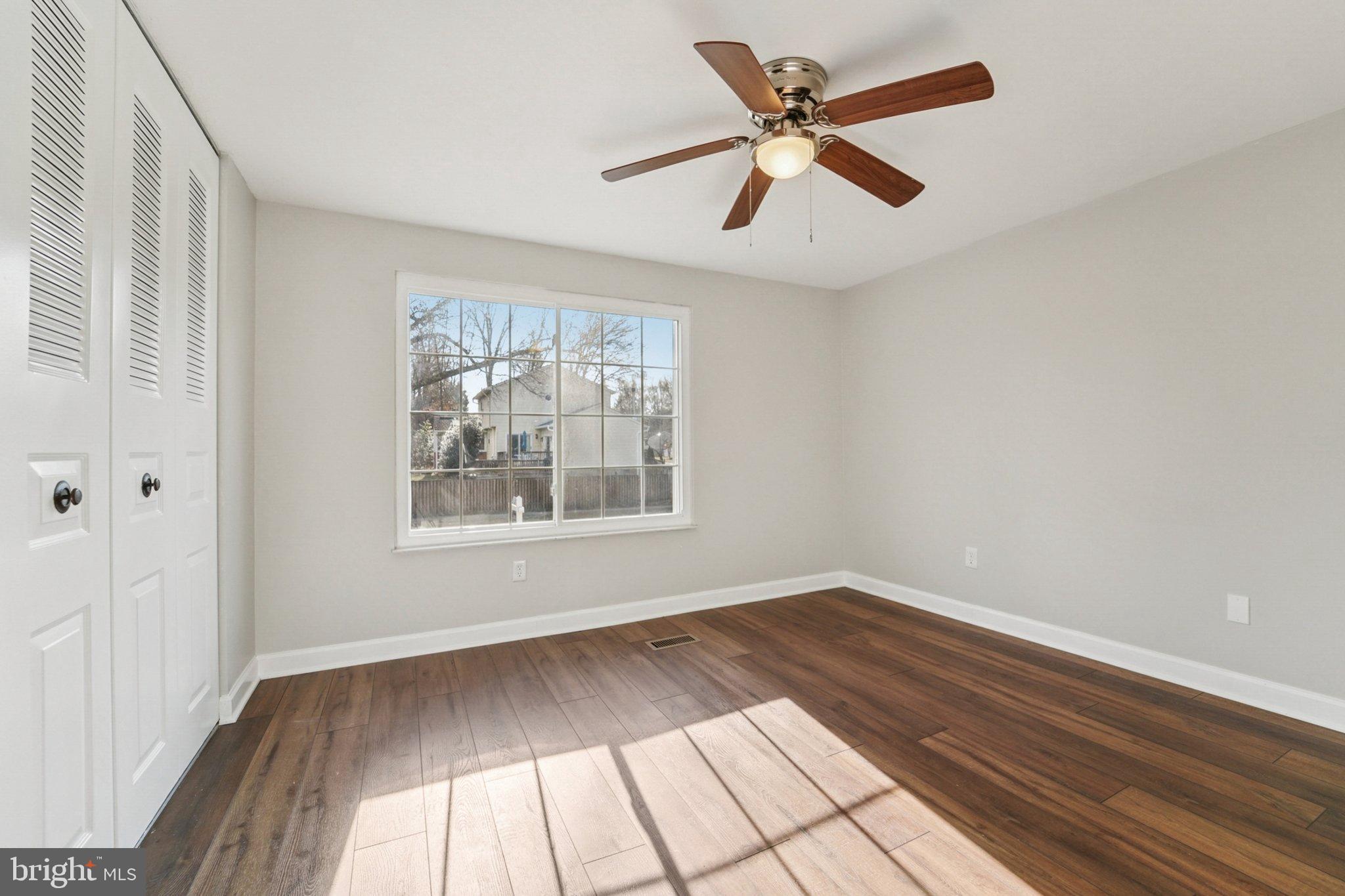 308 Raussell Place Severna Park, MD 21146 - Photo 11 of 31 an empty room with wooden floor fan and windows