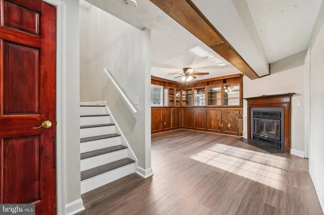 a view of front door with hallway and wooden floor