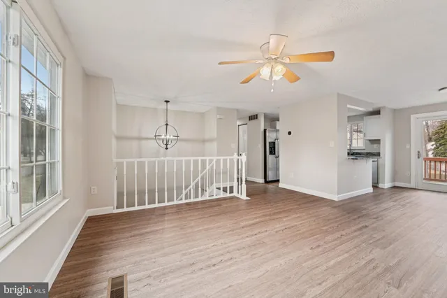 a view of a livingroom with wooden floor and staircase