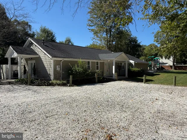 a front view of a house with a yard and trees
