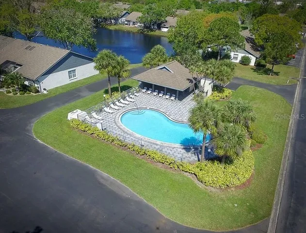 a view of a swimming pool with a yard and plants