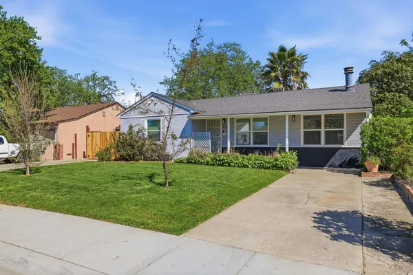 a front view of a house with a yard and potted plants