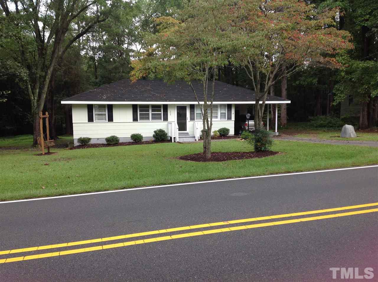 a front view of a house with a yard and trees