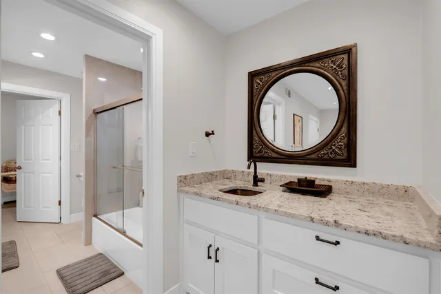 a bathroom with a granite countertop sink a mirror and a vanity