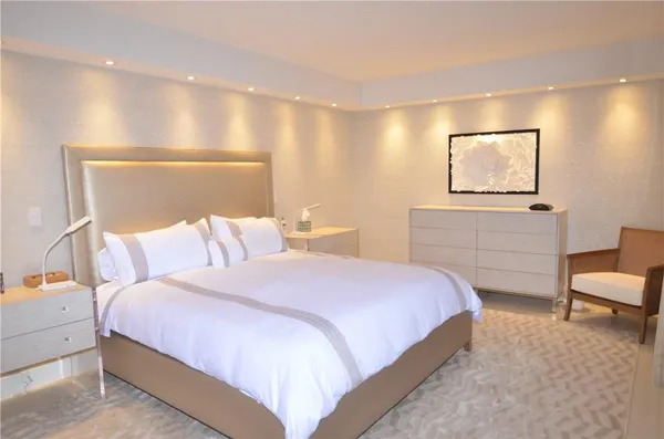 a bedroom with a bed and a painting on the wall