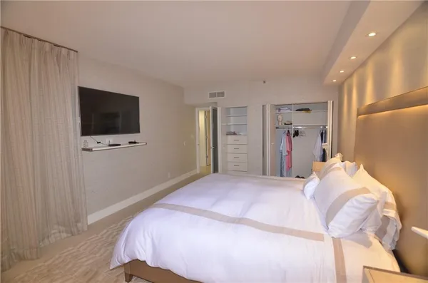 a bedroom with a bed and a flat screen tv