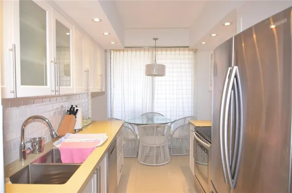 a kitchen with a sink appliances and dining table