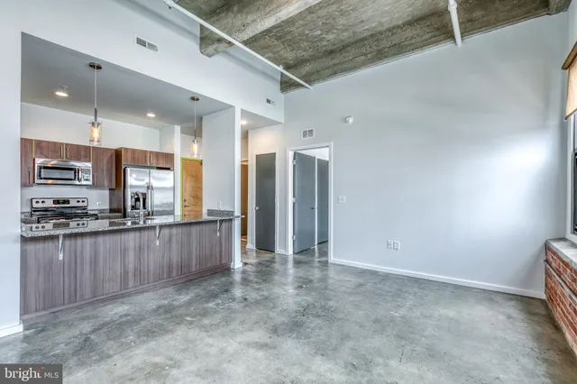 a view of a kitchen with stainless steel appliances granite countertop a refrigerator and a stove top oven