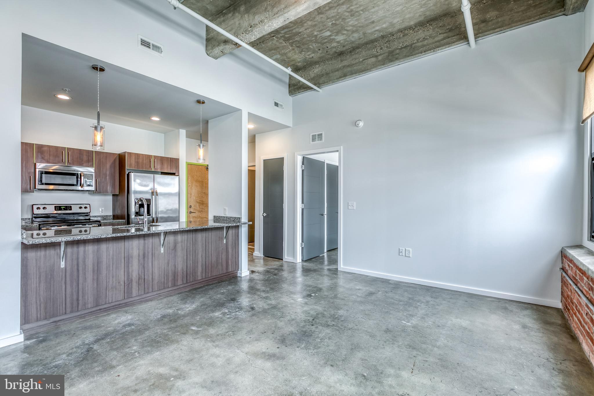 a view of a kitchen with stainless steel appliances granite countertop a refrigerator and a stove top oven