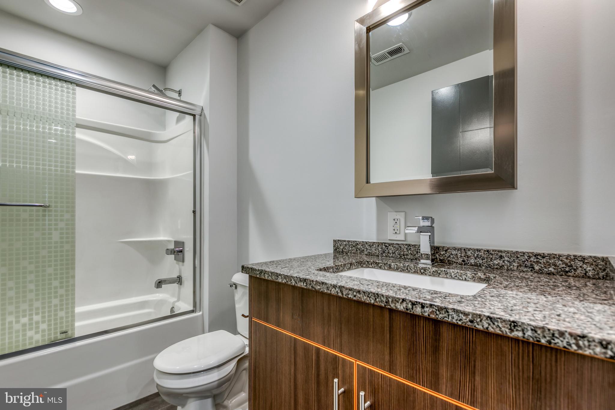4800 Brown Street, Unit 306 Philadelphia, PA 19139 - Photo 4 of 22 a bathroom with a granite countertop sink toilet and shower