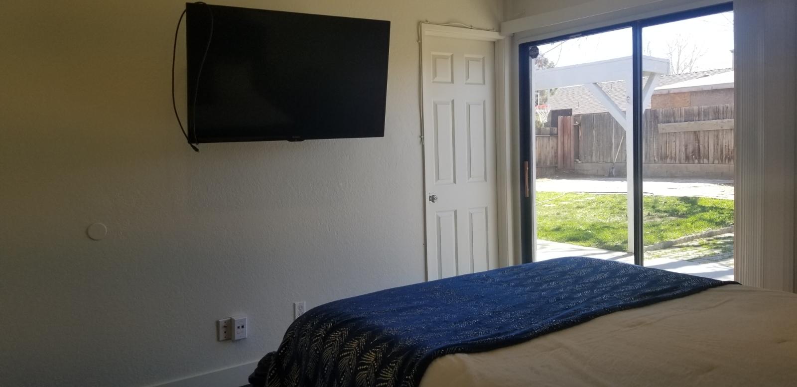 3096 East Avenue R-5 Palmdale, CA 93550 - Photo 16 of 22 a bedroom with a bed and a flat tv screen next to a window