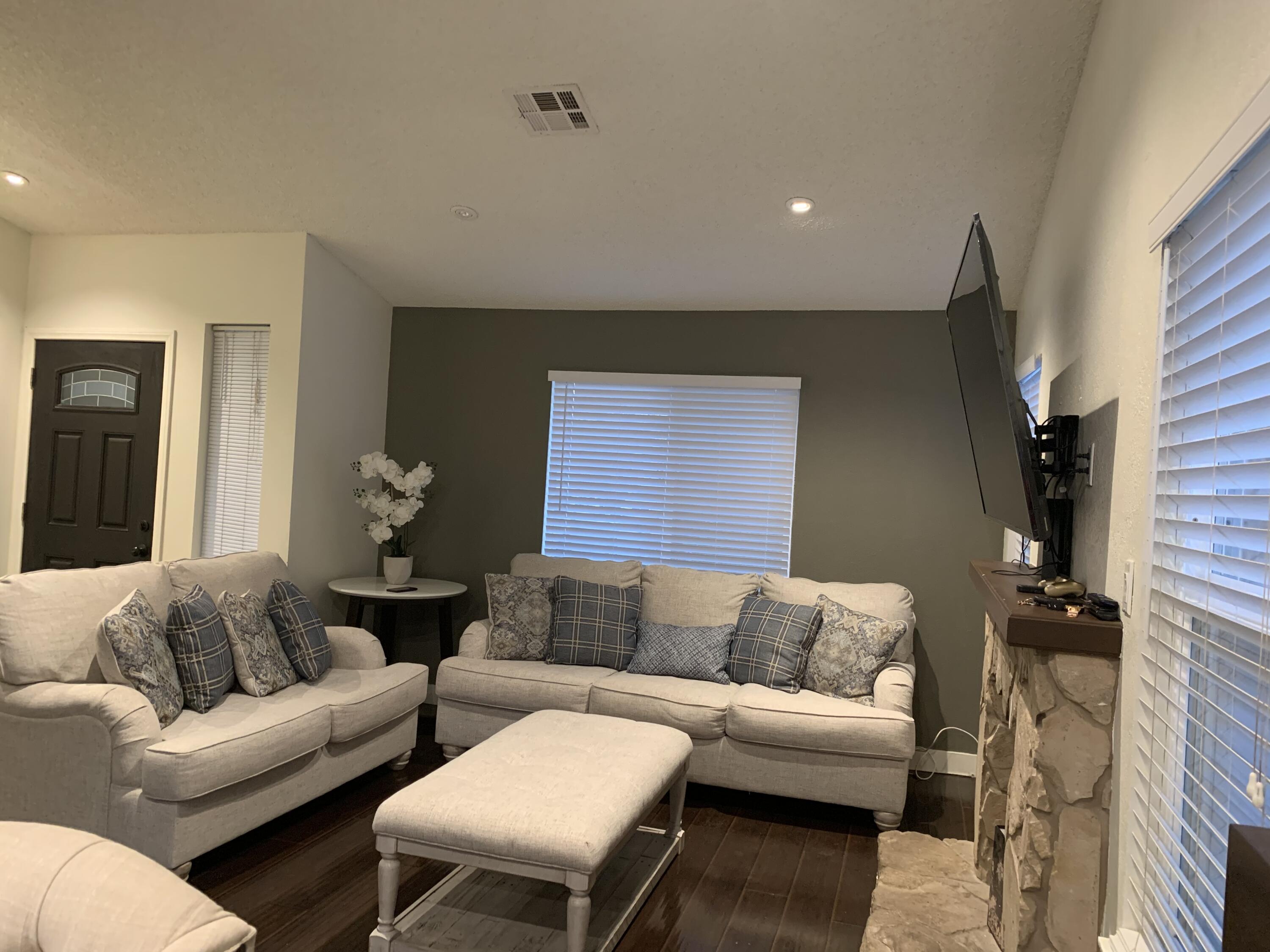 3096 East Avenue R-5 Palmdale, CA 93550 - Photo 3 of 22 a living room with couches and a potted plant on a dresser