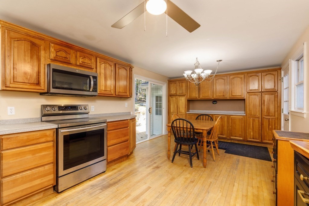283 Mill Street Gardner, MA 01440 - Photo 2 of 30 a kitchen with granite countertop wooden floor dining table and stainless steel appliances
