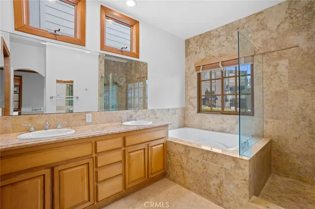 a bathroom with a tub sink and mirror