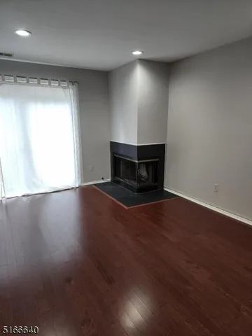 an empty room with wooden floor and fireplace