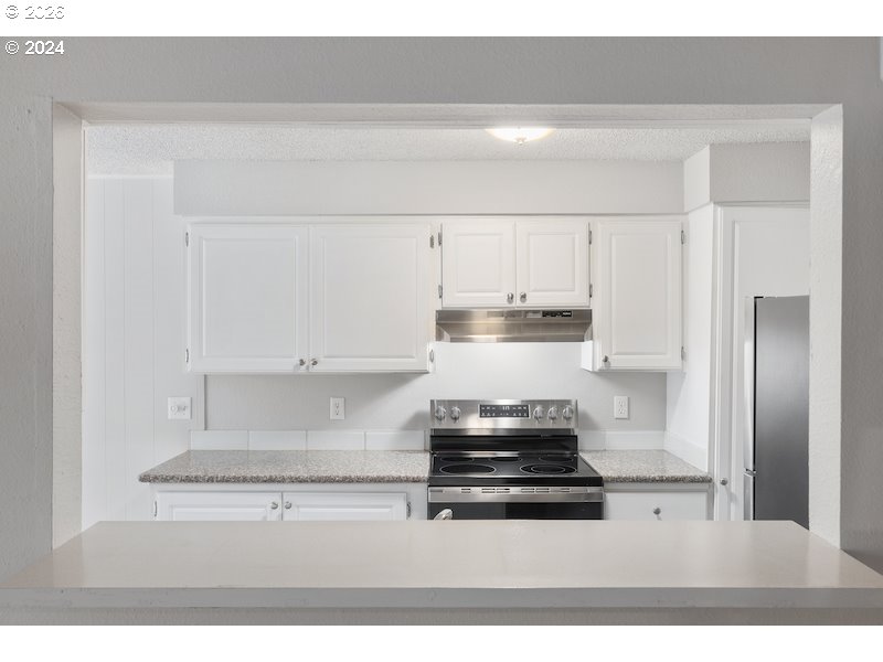 2921 Northeast Rene Avenue, Unit 15B Gresham, OR 97030 - Photo 6 of 22 a kitchen with stainless steel appliances a stove and white cabinets