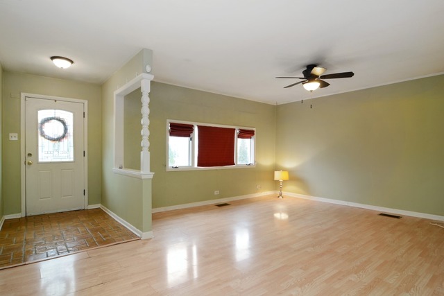 115 East Dennis Road Wheeling, IL 60090 - Photo 2 of 10 a view of an empty room with windows and chandelier fan