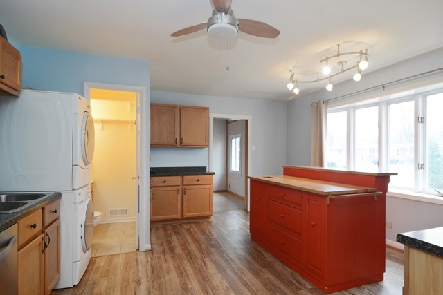 115 East Dennis Road Wheeling, IL 60090 - Photo 5 of 10 a room with kitchen island granite countertop wooden floors and stainless steel appliances