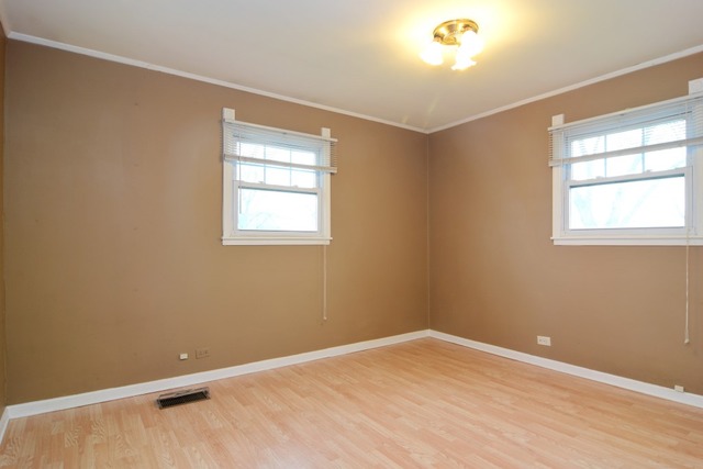 115 East Dennis Road Wheeling, IL 60090 - Photo 6 of 10 a view of an empty room with wooden floor and a window