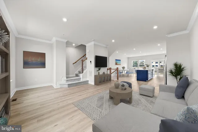 a living room with furniture a flat screen tv and a potted plant