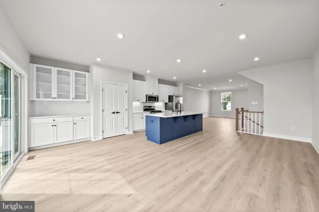 a living room with furniture a wooden floor and kitchen view