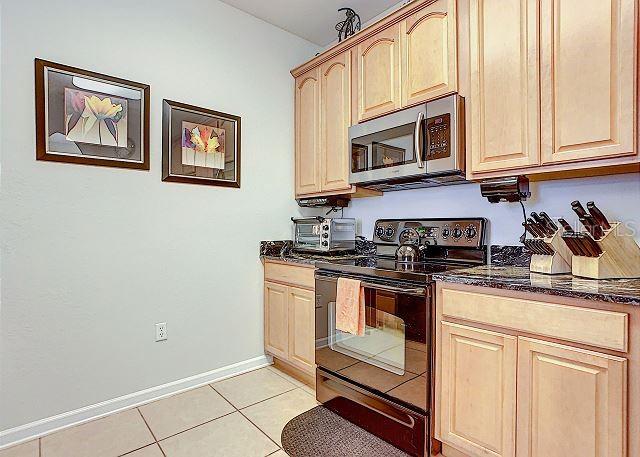 4862 Cayview Avenue, Unit 20909 Orlando, FL 32819 - Photo 12 of 38 a kitchen with stainless steel appliances granite countertop a stove a microwave and a sink