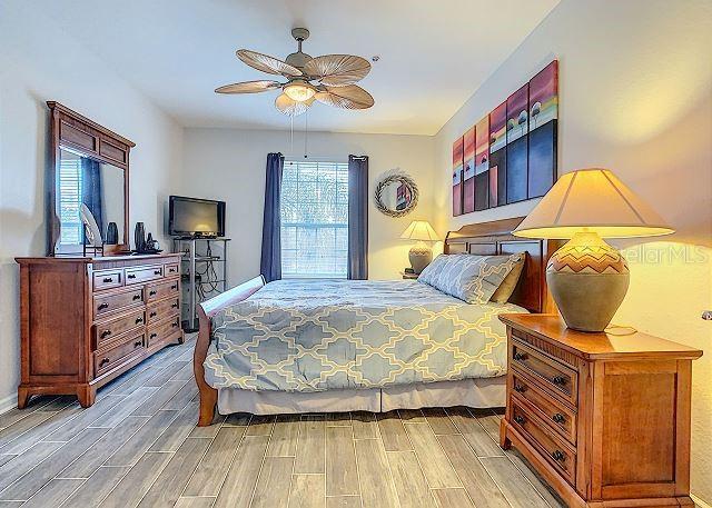 4862 Cayview Avenue, Unit 20909 Orlando, FL 32819 - Photo 19 of 38 a bedroom with a bed and wooden floor