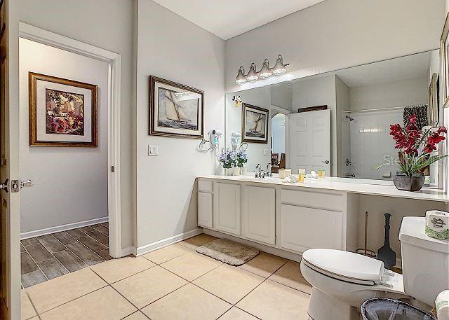 4862 Cayview Avenue, Unit 20909 Orlando, FL 32819 - Photo 23 of 38 a bathroom with a sink mirror and toilet