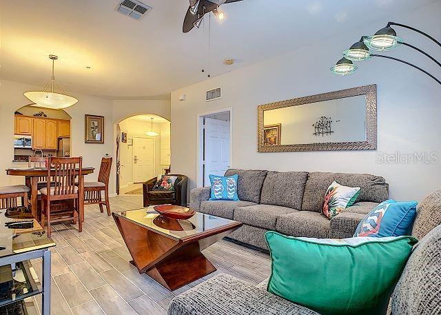 4862 Cayview Avenue, Unit 20909 Orlando, FL 32819 - Photo 8 of 38 a living room with furniture and a chandelier